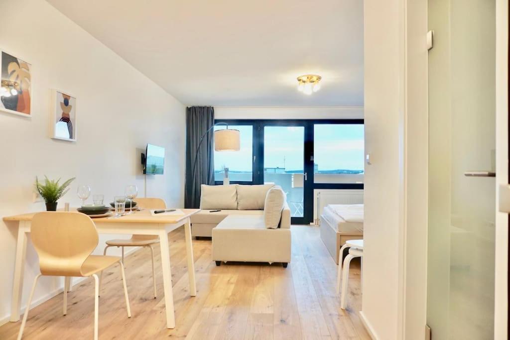 sala de estar blanca con mesa y sofá en NEU modernes Apartment in Top Lage, free Parking max 1,65m Höhe und 1,8m Breite en Karlsruhe