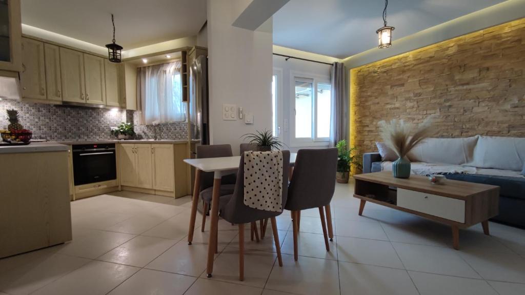 Il comprend une cuisine et un salon avec une table et des chaises. dans l'établissement Iliopetra Apartment, à Naxos Chora