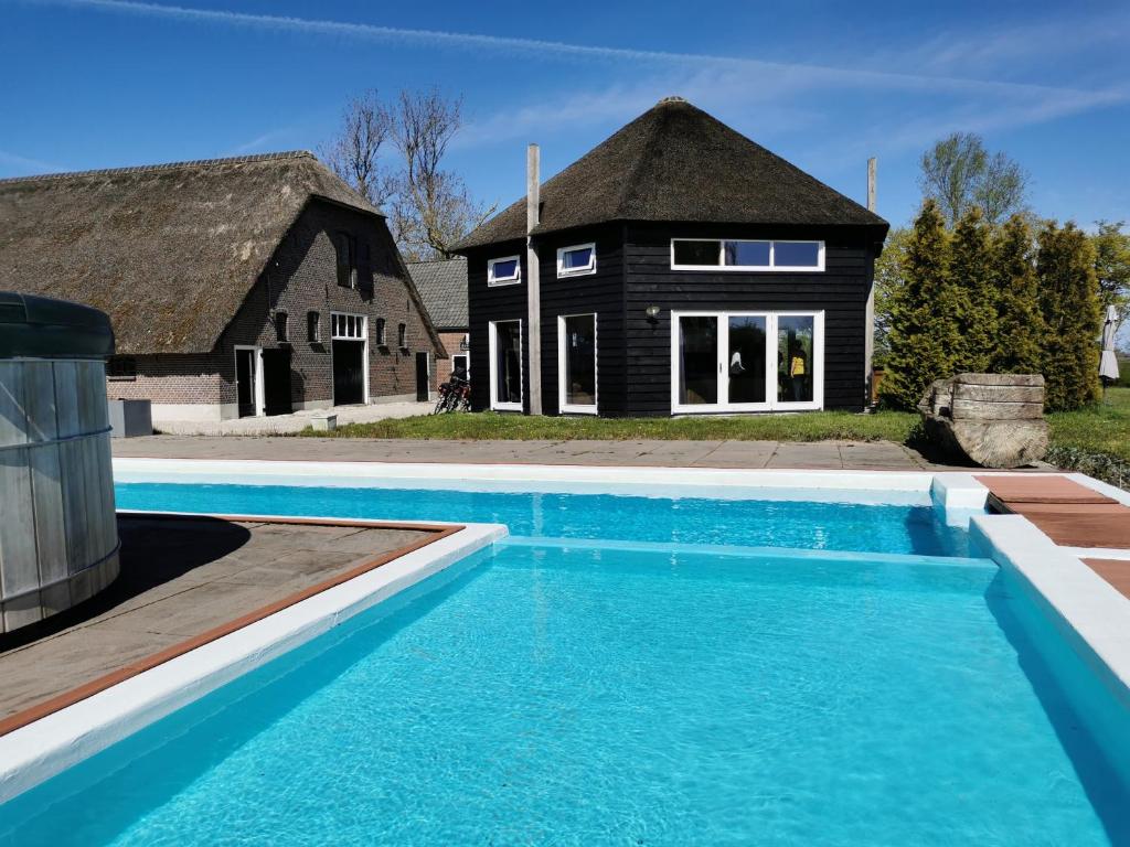 a house with a swimming pool in front of a house at Vacation house Hooihuys in Woerden