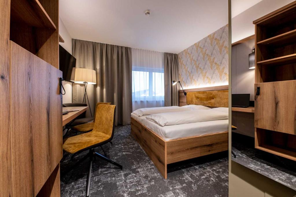 Eggenburg的住宿－Sleep in Premium Hotel Eggenburg，配有一张床和一张书桌的酒店客房