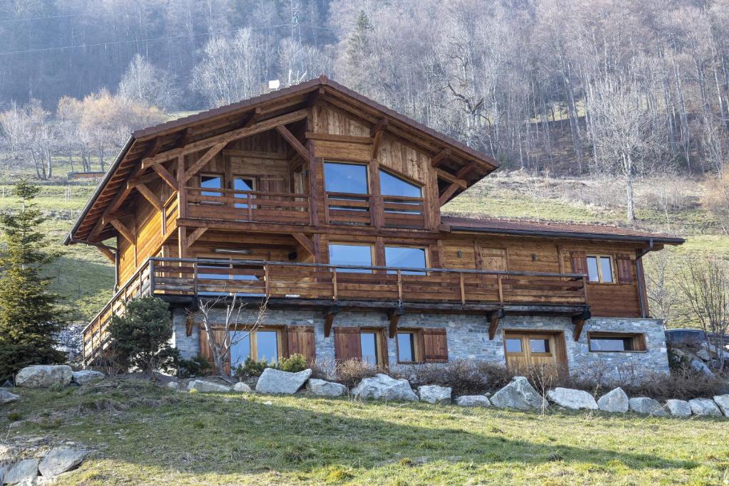 ein großes Holzhaus auf einem Feld in der Unterkunft Chalet face au Mont-blanc in Sallanches