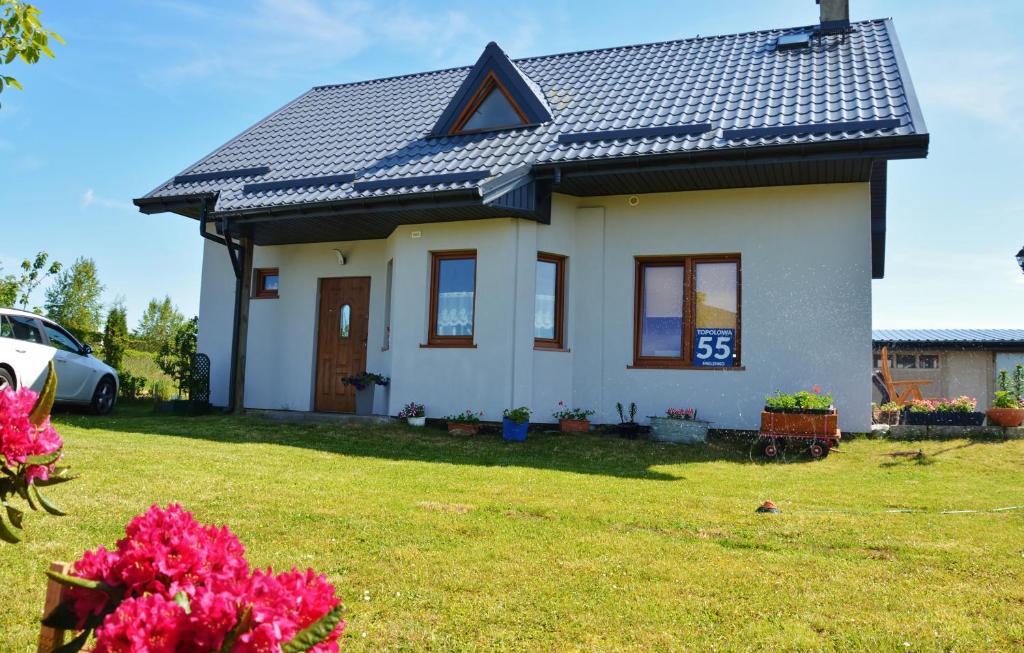 Biały dom z czarnym dachem w obiekcie Pensjonat Wiktoria Mielenko w mieście Mielenko