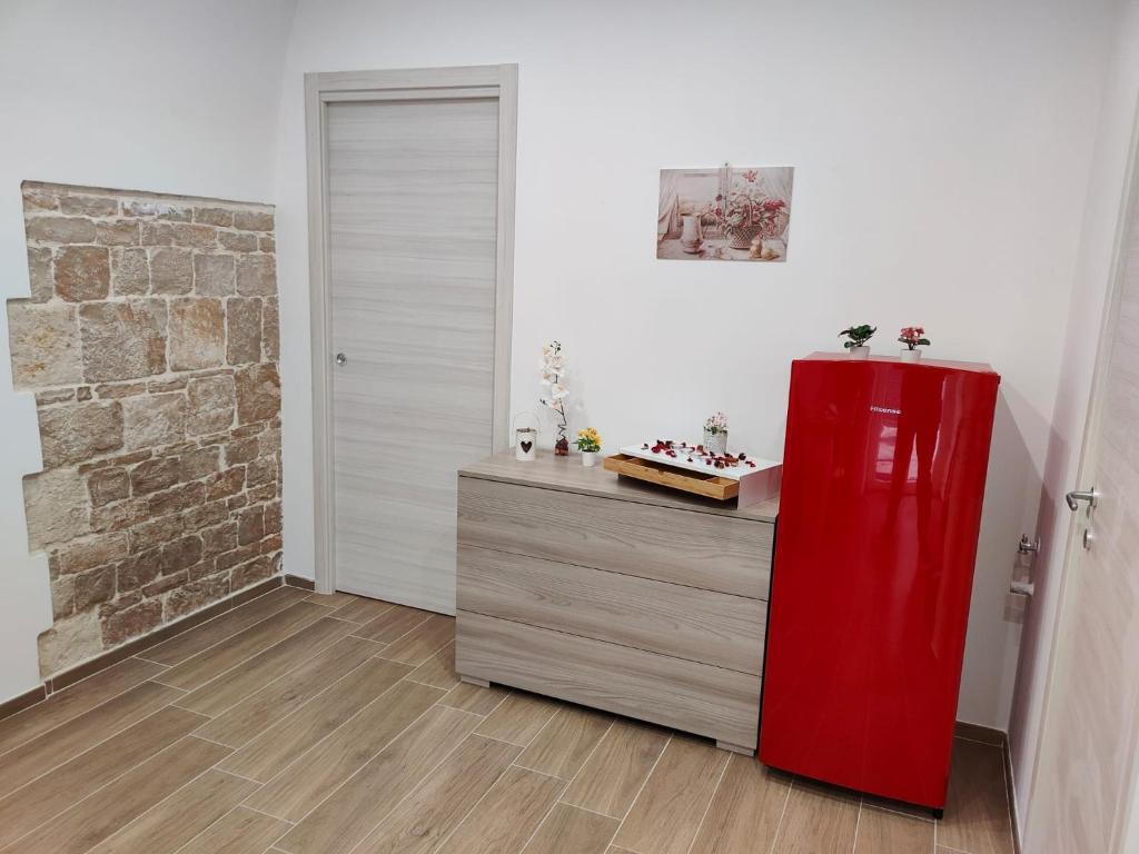 einen roten Kühlschrank in einem Zimmer mit Ziegelwand in der Unterkunft La Prima Dimora Luxury Home in Grumo Appula