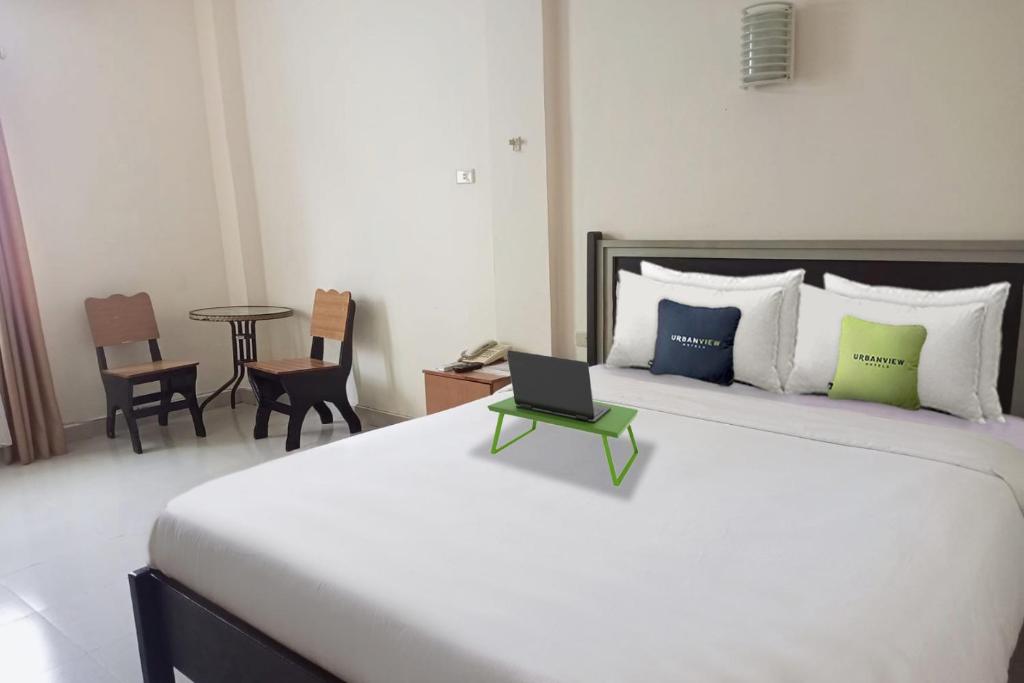 Tempat tidur dalam kamar di Urbanview Hotel Yasminstar Muntok