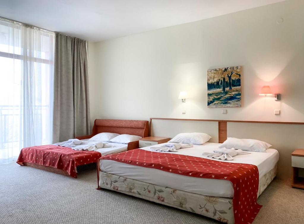 een hotelkamer met 2 bedden en een raam bij Helios Spa Hotel - All Inclusive - Pool & Children Slides - Entertainment in Goudstrand