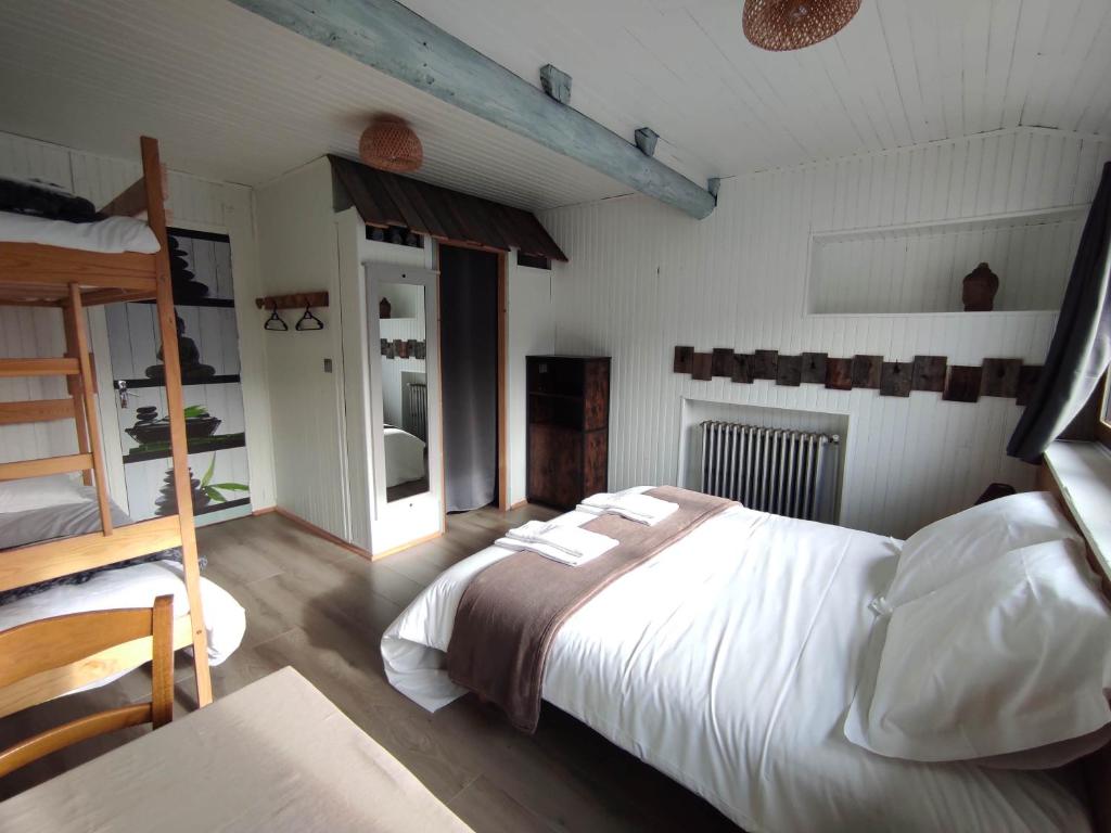 a bedroom with a bed with white sheets and a ladder at Chez Pierrot Chambres d'hôtes B&B in Vallouise