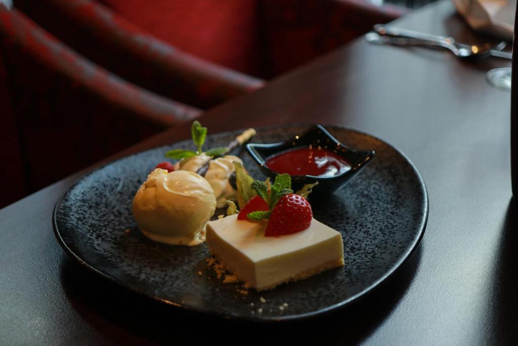 a black plate with desserts on a table at Hotel Haverkamp in Bremerhaven