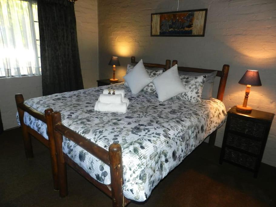 a bedroom with a bed with a table on it at Cozy cottage in the Cradle of Humankind in Muldersdrift