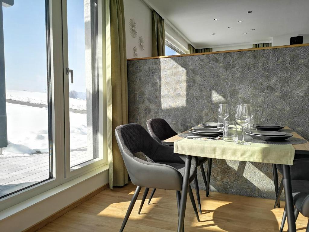 een eetkamer met een tafel en stoelen en een raam bij Good times @ Salzburg in Habach