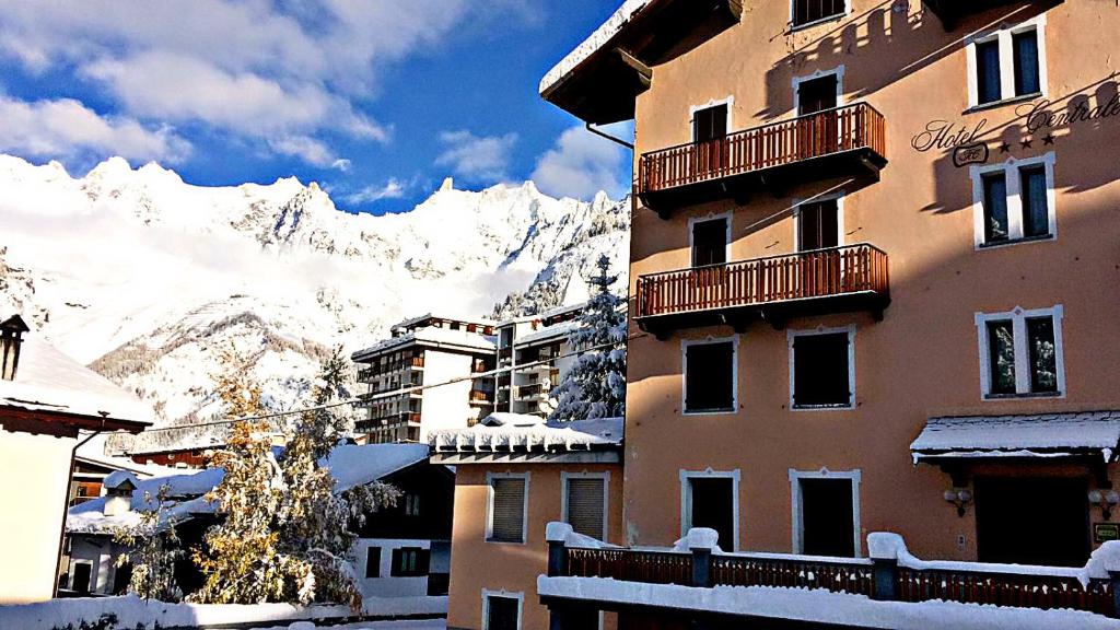 a building with a snow covered mountain in the background at Centrale in Courmayeur