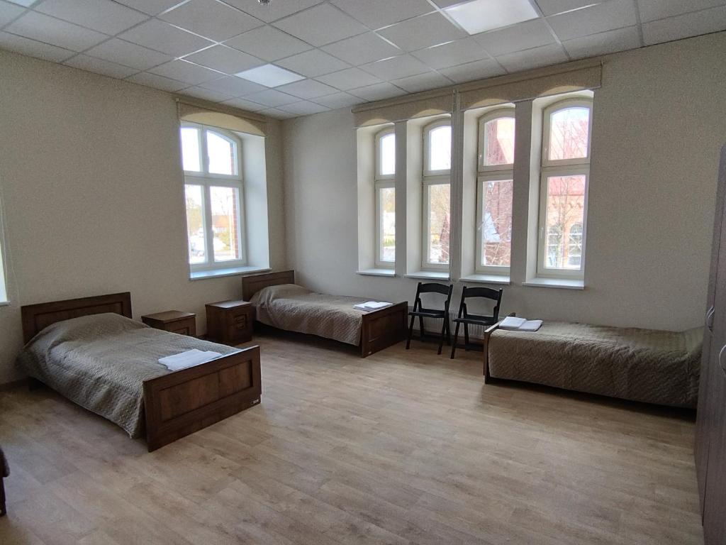 een kamer met drie bedden en ramen erin bij Eglutė in Šilutė