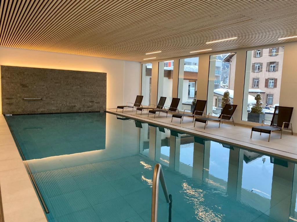 una piscina in un edificio con sedie intorno di Residenz by Meierhof a Davos