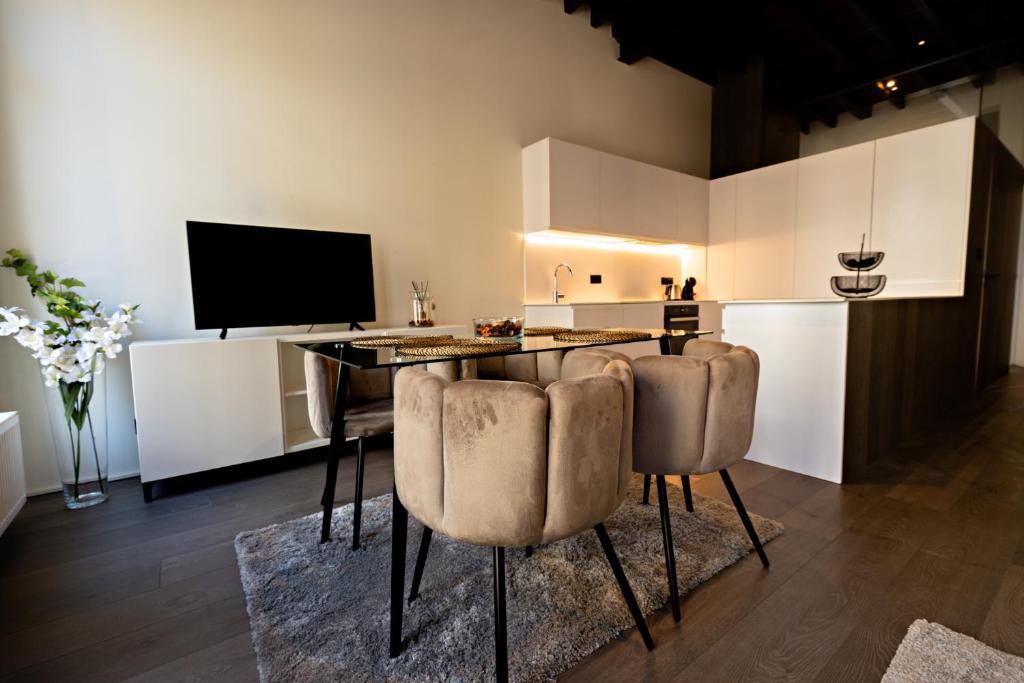 a kitchen with a table with chairs and a television at Luxury Suites Princess in Antwerp