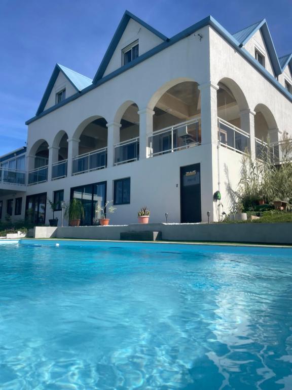 una casa con piscina frente a ella en Villa Blue Lodge, en Saint-Louis