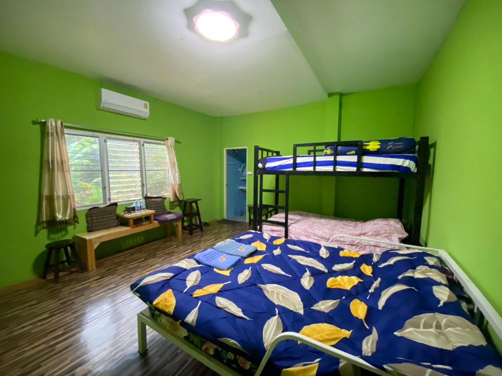 パーイにあるRed orchid pai Thailandの緑の部屋に二段ベッド付きのベッドルームがあります。