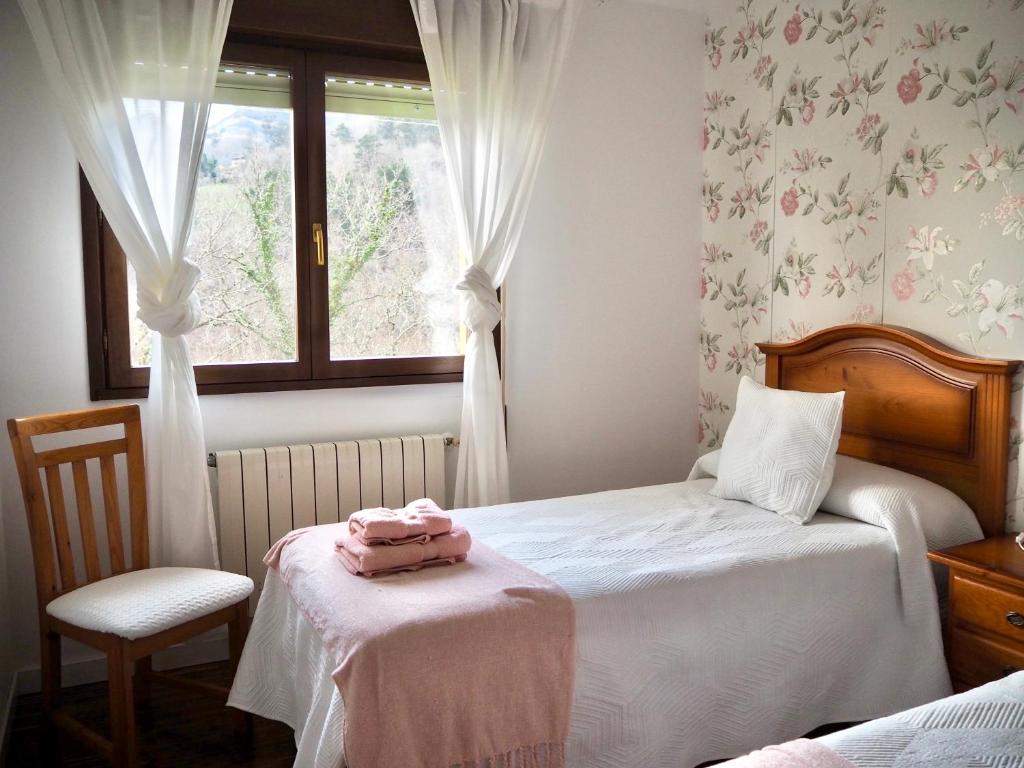 a small bedroom with a bed and a window at Finca La Cuesta in Cangas de Onís