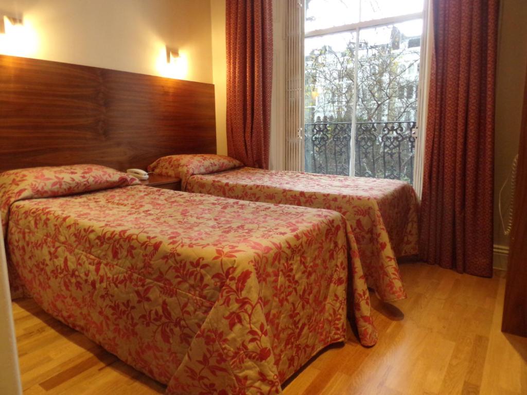 a hotel room with two beds and a window at Wedgewood Hotel in London