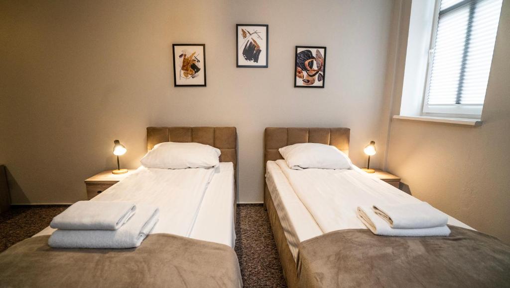 2 Einzelbetten in einem Zimmer mit 2 Lampen in der Unterkunft Villa Pallas in Olsztyn