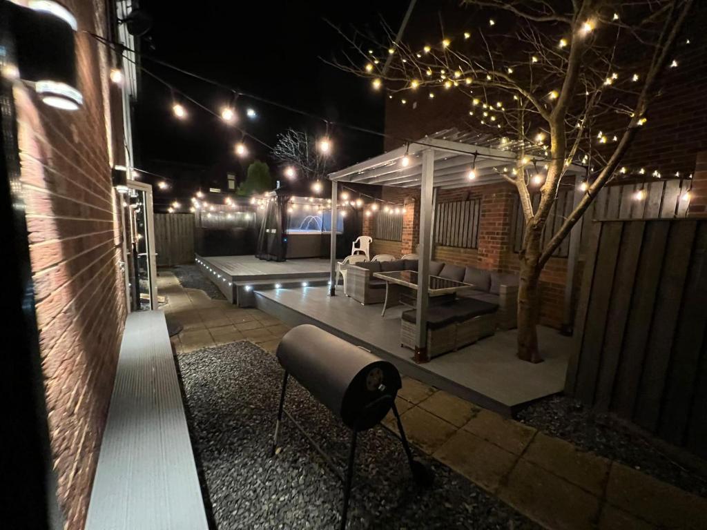 a patio at night with a couch and a table at Numero Uno Detached Aparthouse in Newcastle upon Tyne