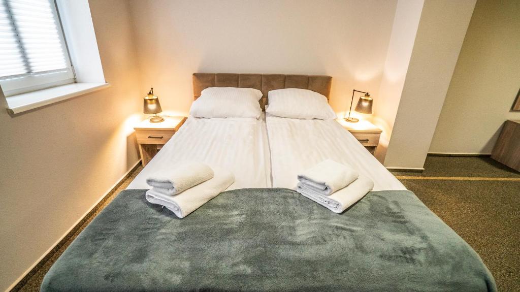 a bedroom with a large bed with towels on it at Villa Pallas in Olsztyn