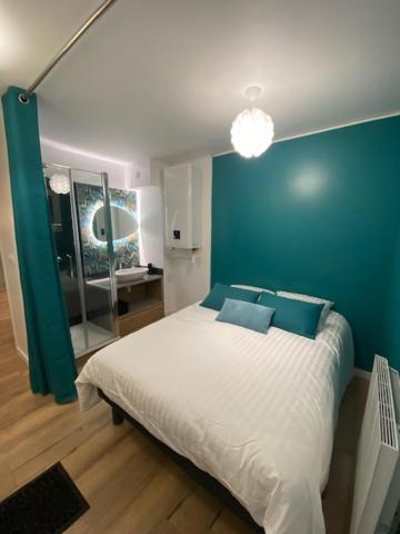 Schlafzimmer mit einem Bett mit blauer Wand in der Unterkunft Vue sur dunes ! in Sangatte