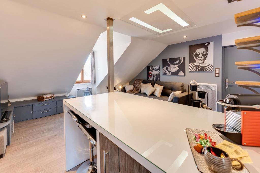 Una cocina y sala de estar con una gran encimera blanca. en Le Duplex atypique superbe coeur centre ville, en Annecy