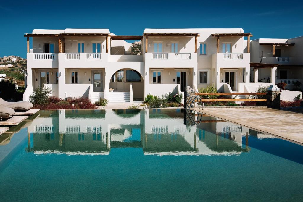 a house with a swimming pool in front of it at Ammothines Cycladic Suites in Naxos Chora