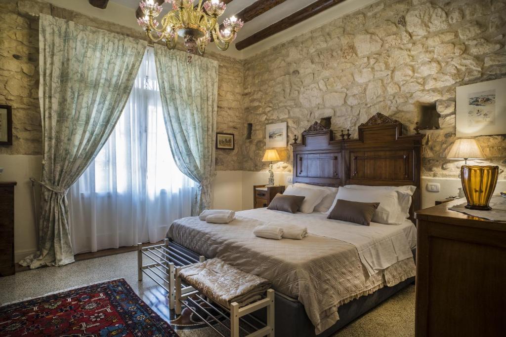 a bedroom with a large bed and a large window at Il Calamaio in Verona