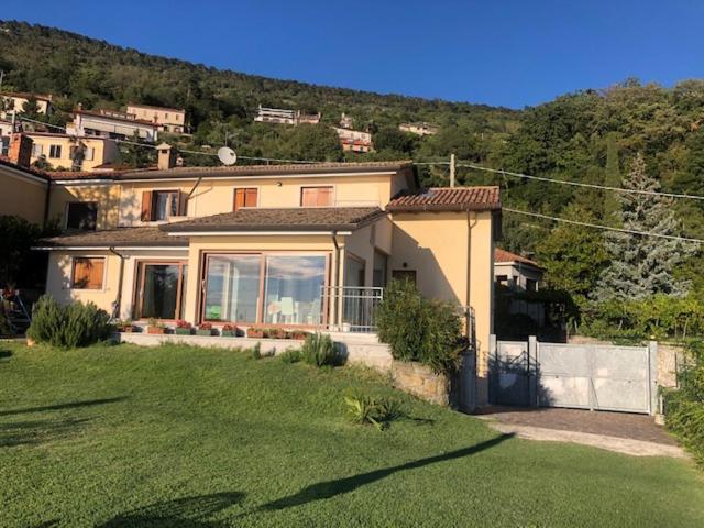 ein Haus mit einem großen Garten mit grünem Rasen in der Unterkunft Barcola mare apartment in Triest