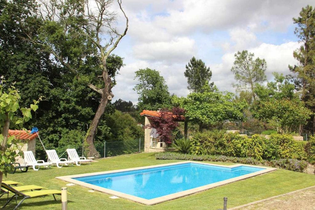 a swimming pool in the yard of a house at Casa da Boavista Camélias de BastoTurismo Rural in Celorico de Basto