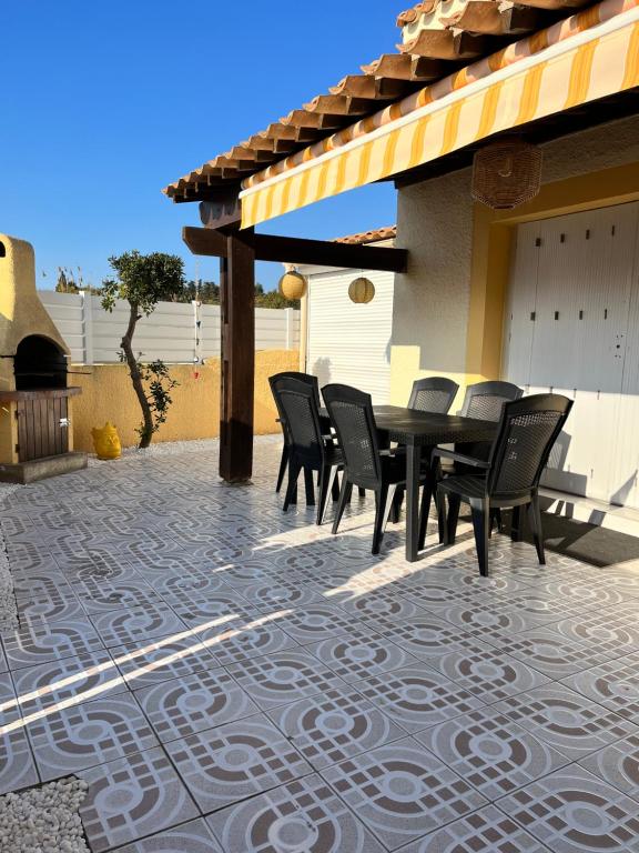patio ze stołem i krzesłami na patio w obiekcie Maison Résidence Golf Club Cap Agde w Cap d'Agde