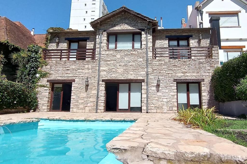 uma casa de tijolos com uma piscina em frente em Precioso Chalet Vista Mar em Mar del Plata