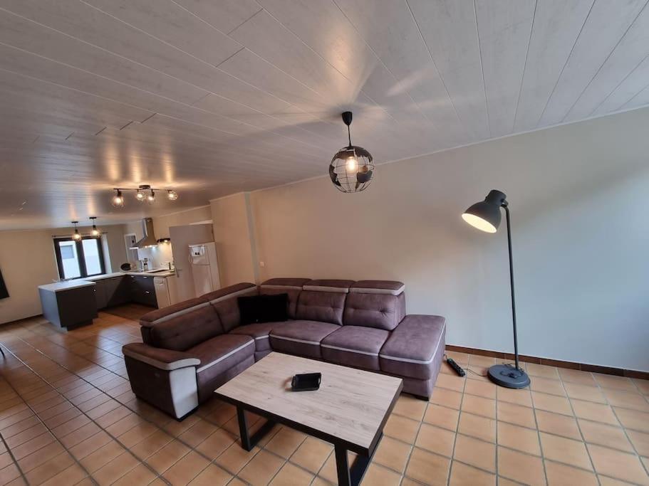 ein Wohnzimmer mit einem Sofa und einem Tisch in der Unterkunft Le gîte du boulanger in Alle