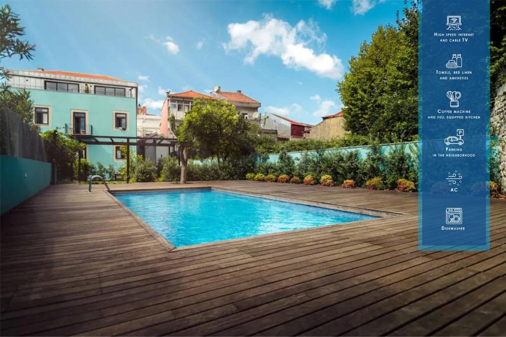 een zwembad in een tuin met een houten terras bij Swimming Pool Luxury House 1 in Porto