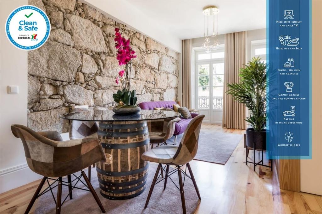 comedor con pared de piedra, mesa y sillas en Wine Luxury House, en Oporto