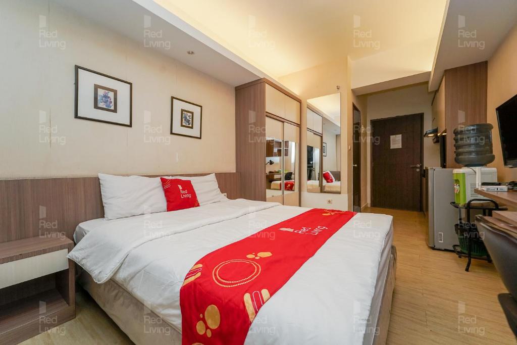 ein Schlafzimmer mit einem großen Bett mit einer roten Decke in der Unterkunft RedLiving Apartemen Easton Park Jatinangor - Azhimah Rooms in Sumedang