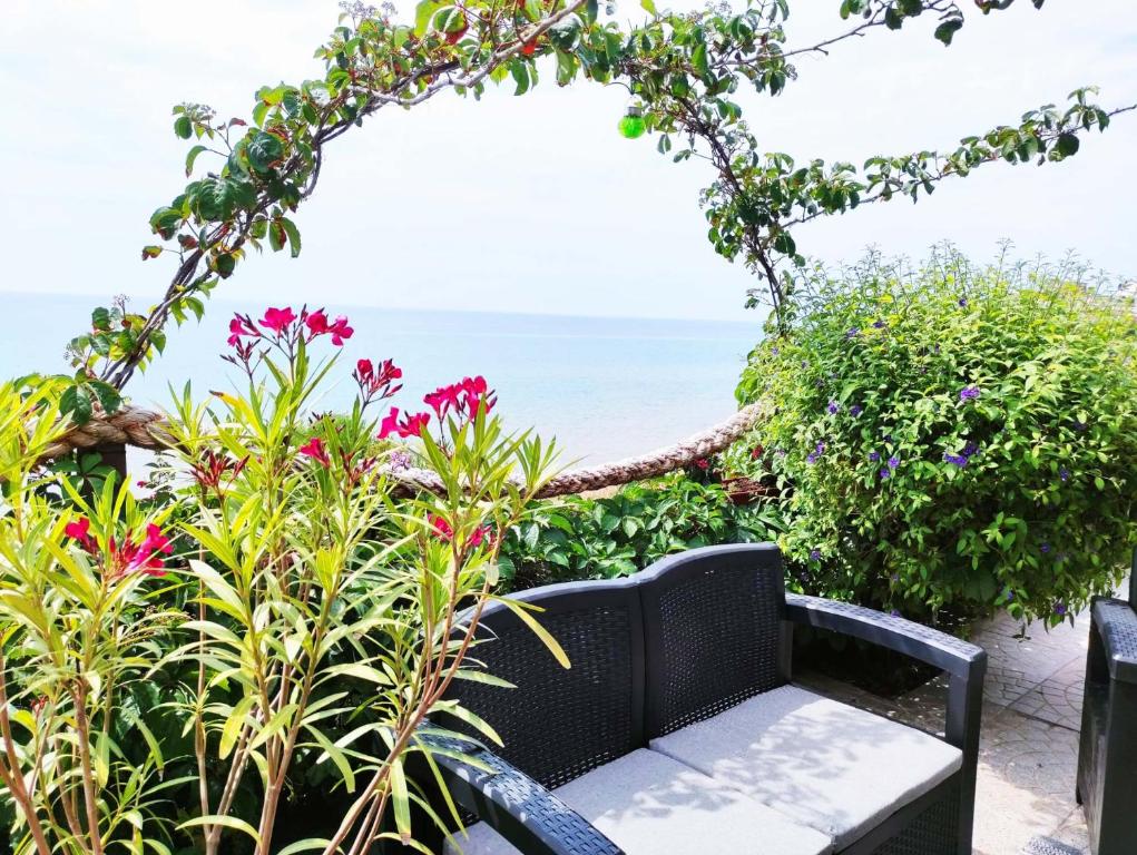 イーゾラ・ディ・カーポ・リッツートにあるIppocampo Holiday Homeの海の前に座る黒籐のベンチ