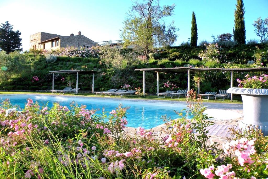 een zwembad in een tuin met bloemen bij Capanna Suites in Luia