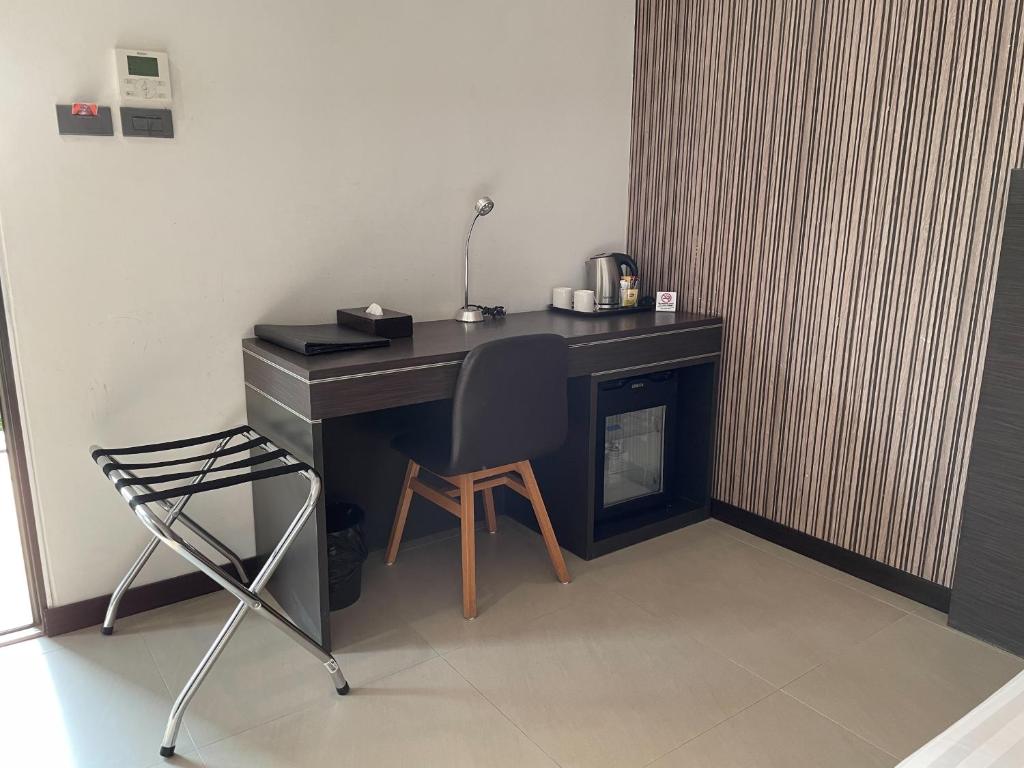 a desk with a chair and a desk with a lamp at Amanta Hotel Nongkhai in Nong Khai