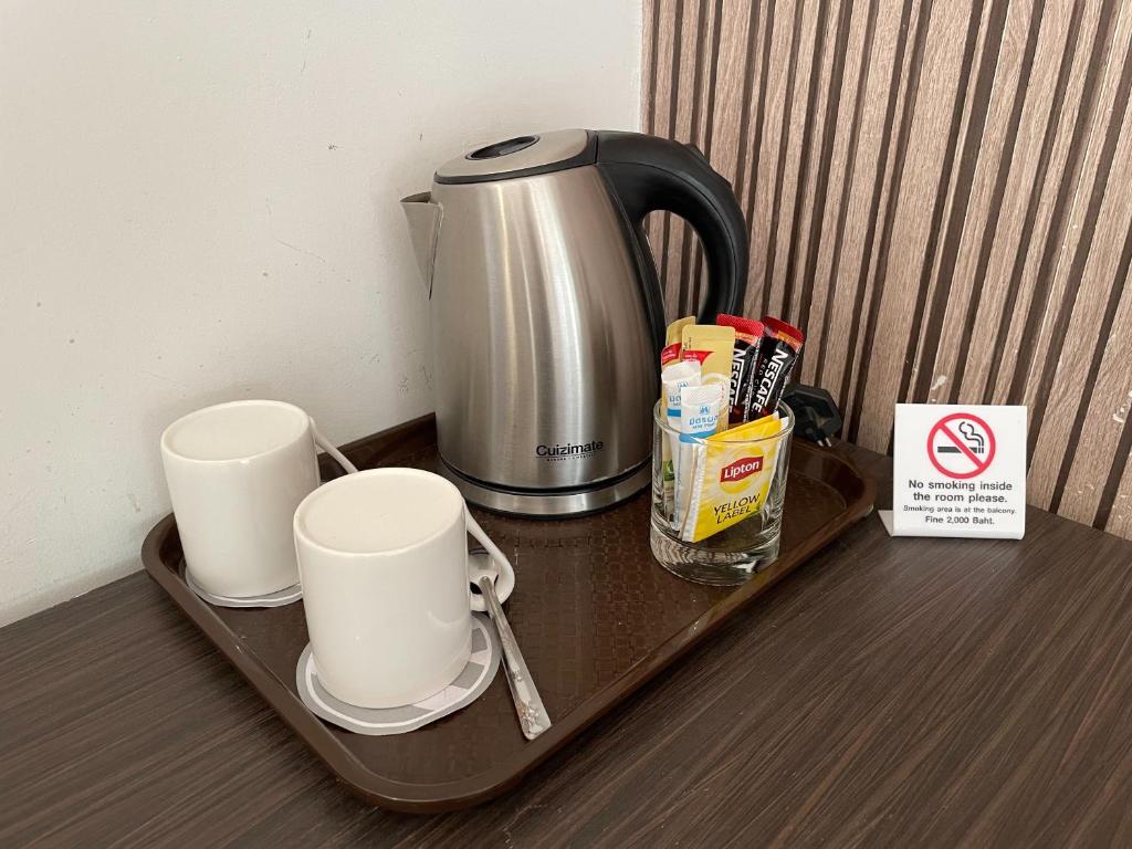 a tray with two cups and a coffee maker on a table at Amanta Hotel Nongkhai in Nong Khai