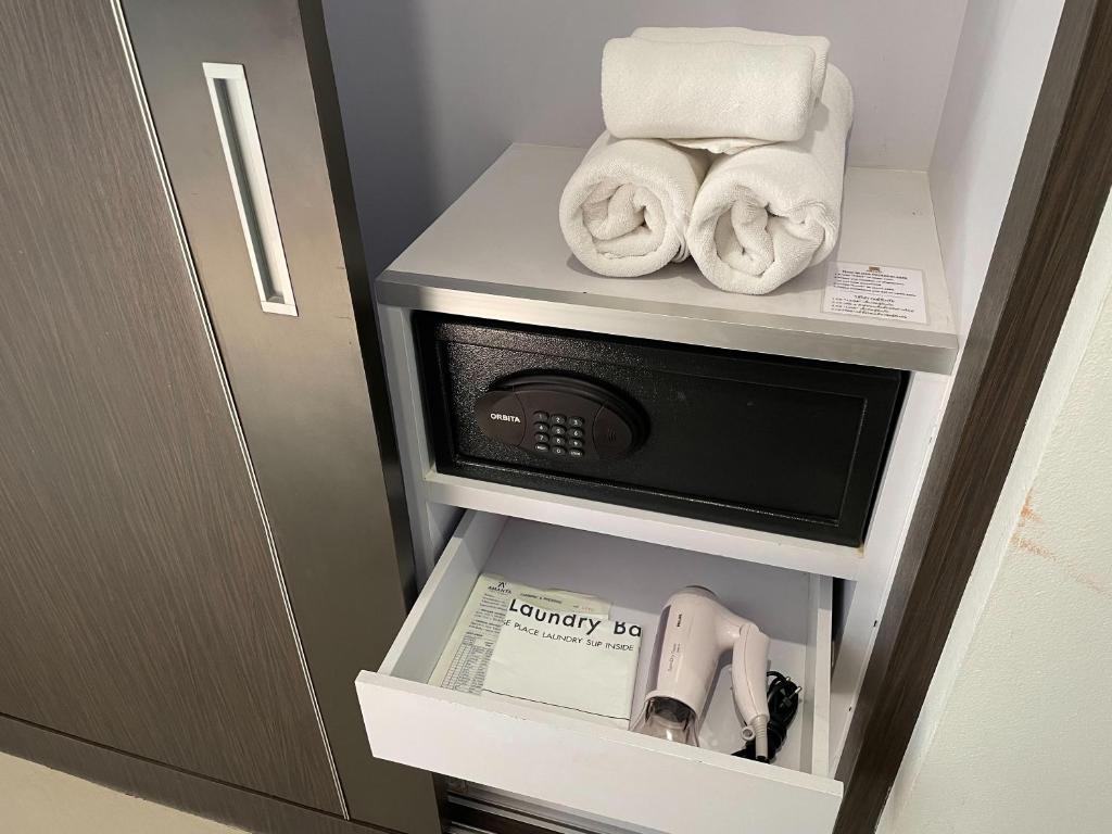 a hotel room with a microwave and towels at Amanta Hotel Nongkhai in Nong Khai