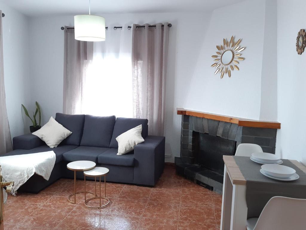uma sala de estar com um sofá azul e uma lareira em El Fuerte em Benamaurel
