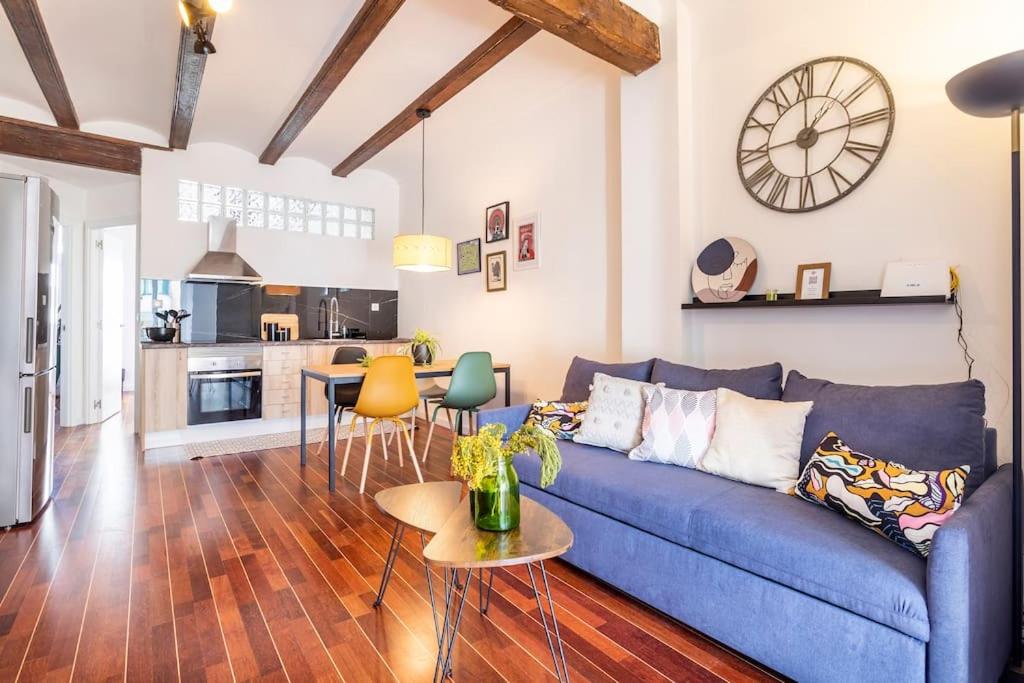 sala de estar con sofá azul y cocina en 7P céntrico piso con encanto, en Valencia