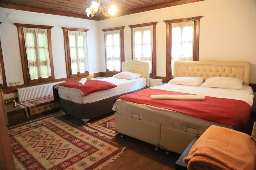 a bedroom with two beds in a room with windows at mehmet efendi in Safranbolu