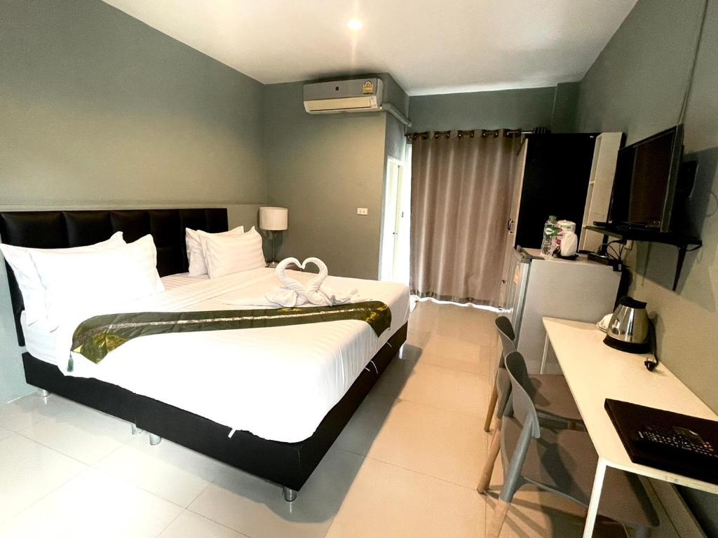 Kangaroo Residence Udonthani في أودون ثاني: غرفة نوم مع سرير أبيض كبير ومكتب