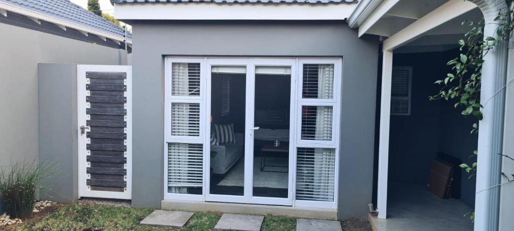 eine Terrassentür mit Glaseinsätzen an einem Haus in der Unterkunft Cottage in Sandton in Johannesburg