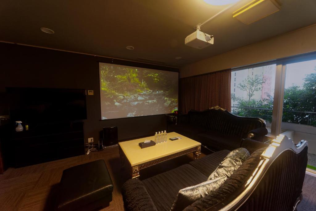 a living room with a couch and a large screen at 熱海の隠れ里 in Atami