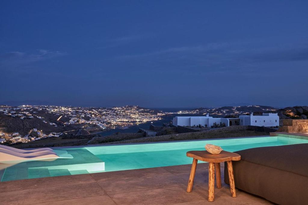 a bench sitting next to a swimming pool at night at Annez Villa with Private Pool Panoramic Sea View in Mikonos