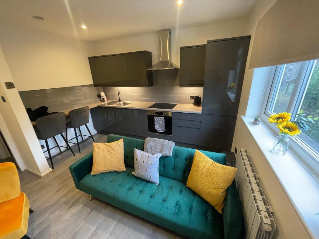 un soggiorno con divano verde e una cucina di Modern Cosy 1 Bed Apartment near City Centre~Double Bed~Parking a Manchester