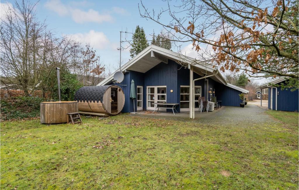 a blue building with a barrel next to a yard at 4 Bedroom Gorgeous Home In Oksbøl in Oksbøl